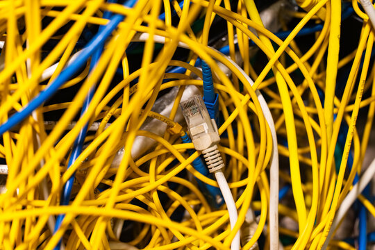 Concept of untidy messy network infrastructure with cables chaotically connected to data center