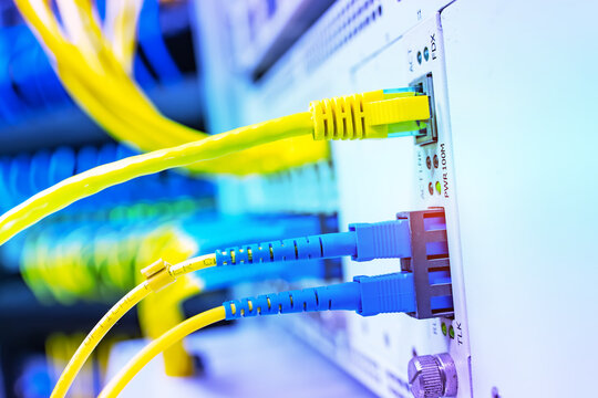 Fiber Optic cables connected to an optic ports and Network cables connected to ethernet ports and UTP Network