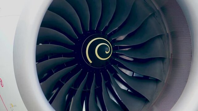 Close up shot of modern commercial aircraft turbofan jet engine spinning blades spinner cone with yellow spiral mark preflight inspection aerospace engineering aviation background stock footage