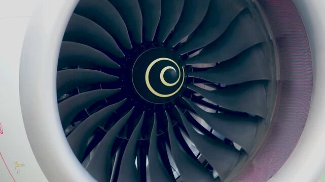 Full Frontal Frame View of Spinning Commercial Jet Engine Fan Blades and Center Spiral Nose Cone Visualizing Modern Airplane Power Mechanics and Airport Ground Operations Footage