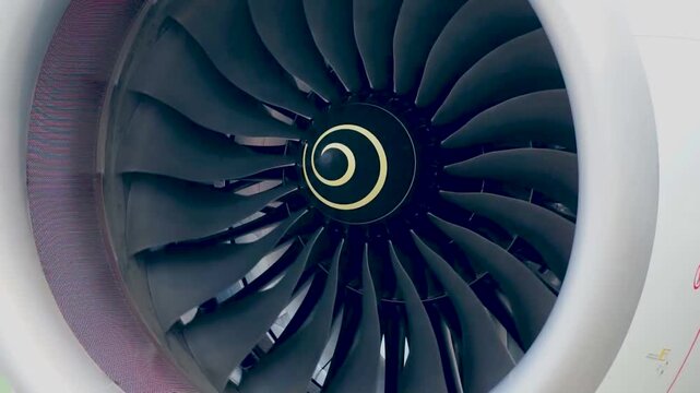 Medium Close Up Shot of Commercial Aircraft Engine Nacelle Cowling and Spinning Jet Turbine Blades with White Spiral Center Cone Visualizing Modern Jetliner Power and Maintenance Inspection
