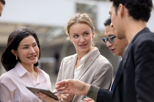 Business teamwork concept. diverse professional colleagues discussing ideas and sharing tablet outdoors in corporate district. teamwork, business, team, collaboration, tablet.