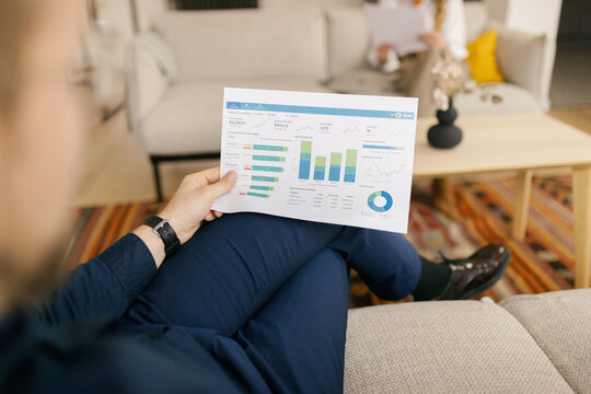 Man analyzes financial chart during an office meeting with a woman
