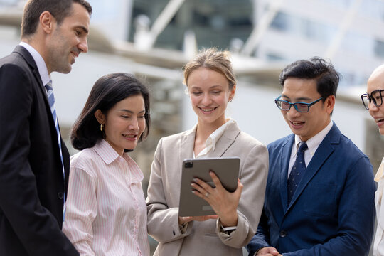 Business teamwork concept. diverse professional colleagues discussing ideas and sharing tablet outdoors in corporate district. teamwork, business, team, collaboration, tablet.