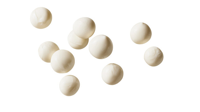 Fresh white mozzarella cheese balls arranged in a scattered pattern