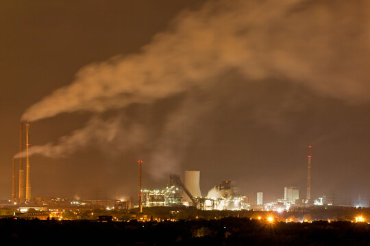 Germany, Nordrhein-Westfalen, Duisburg, View of smoke stacks of industrial plant at night