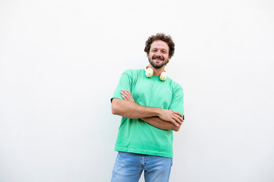 A happy man wears a green shirt against a white background