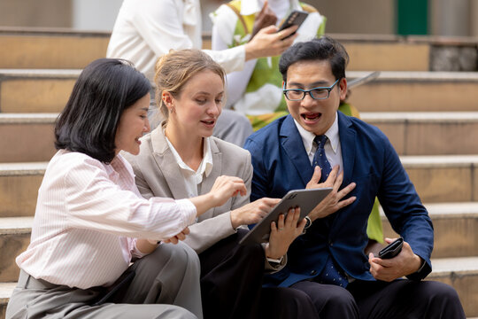 Business teamwork concept, Businessperson brainstorm colleagues discussing ideas and using tablets together while sitting outdoors in corporate setting. teamwork, business, collaboration, tablet.