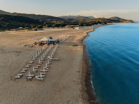 Drone captures an empty beach resort along the coastline at sunset