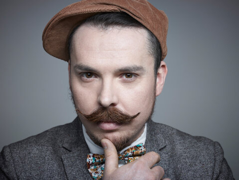 Portrait of mid adult man against grey background, close up