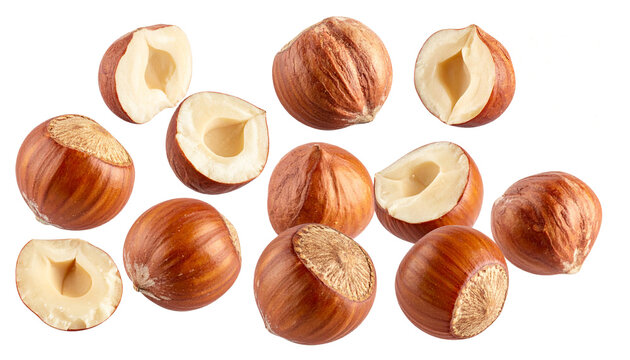 Whole hazelnuts and halved hazelnuts falling through the air, isolated on transparent background