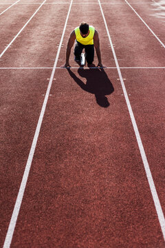 Runner on tartan track in starting position