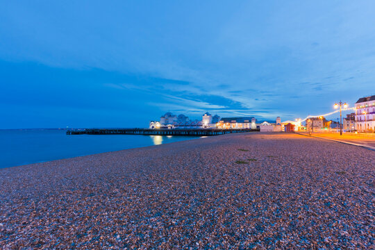 South Parade Pier illuminates the pebble beach at dusk in Portsmouth