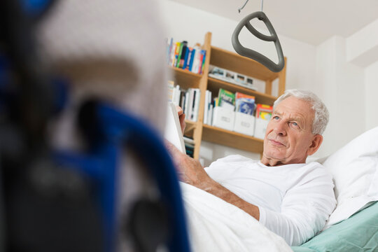 Senior man rests in a medical bed at an apartment sharing community