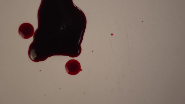 Slow motion top view zoom in of dark blood dripping into pool, off-center left layout, eerie suspenseful mood for thriller background⁠