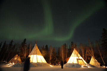 Northern lights over glowing tipis in the snow, Yellowknife © 大祐 小林