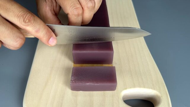 ⁠Slicing Japanese Red Bean Jelly Yokan with Knife on Wooden Cutting Board, Close Up 4K⁠