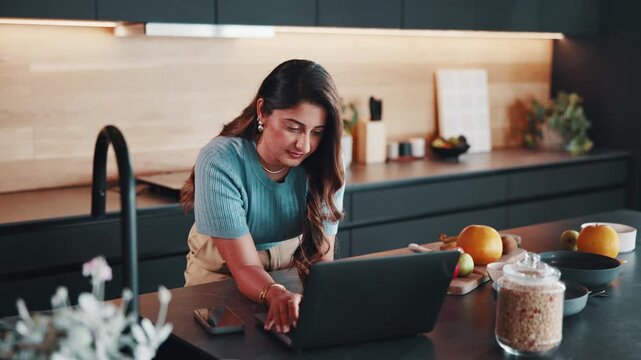 Woman, laptop and typing in home for remote work, notes or article with editing and productivity. Freelancer, pc or writing for email feedback, proofreading or workflow for creative report in kitchen