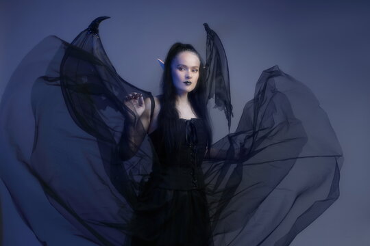 Gothic Mature Woman 40s as Dark Elf with Wings in Blue Mist