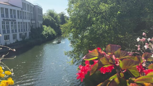 Picturesque view of the Neckar river in the university city of Tubingen, Germany. Lush green trees and flowers on a sunny summer day