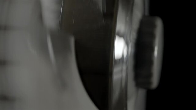 Oscillating fan blades move behind a metal grille in an indoor close-up.