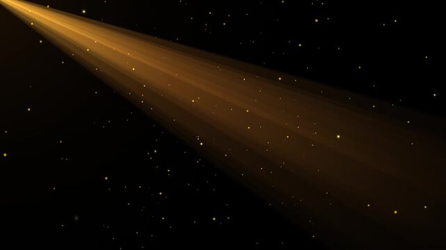 Golden light beam illuminating sparkling particles against dark background abstract motion