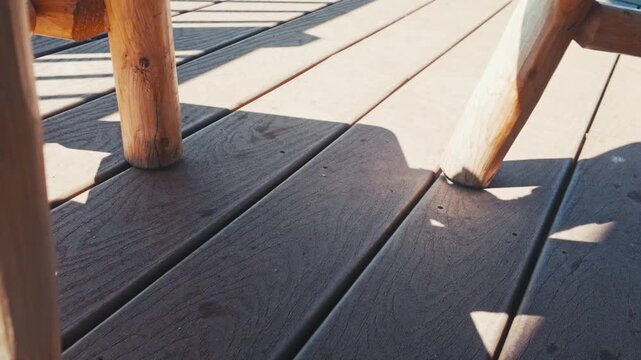 A squirrel on a deck standing still then running off screen.
