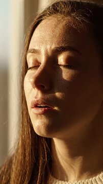 A Serene Moment of Reflection: Capturing a Young Woman's Peaceful Expression Bathed in Soft Light, Lost in Thoughts of Tranquility and Calmness
