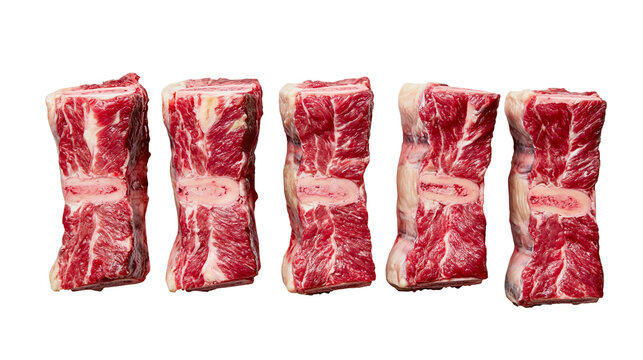 Five raw beef short rib cuts with visible bone and marbled red meat texture