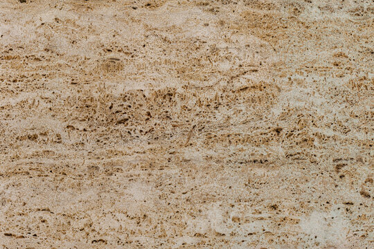 High-quality beige travertine stone texture featuring natural mineral patterns, subtle pores and warm earthy tones, suitable as a background for design.