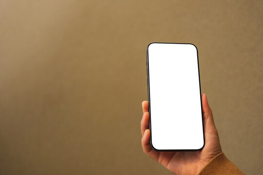 Mockup image of a woman holding mobile phone with blank desktop screen in cafe