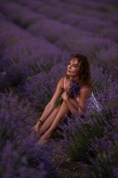 Lavender field relaxation features a young woman holding a bouquet of Lavandula angustifolia during a golden summer sunset