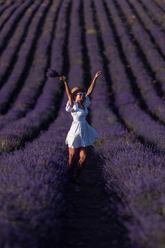 Woman lavender field joyful tourist raising arms with flower bouquet in provence.