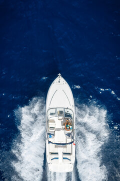 Aerial overhead view of a motorboat or yacht cruising with high speed over the ocean with copy space