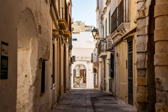 Picturesque alleyways in the historic center of Gallipoli, with warm summer light illuminating traditional buildings in the old town, Salento, Puglia, Italy.