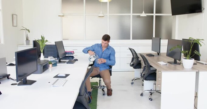Lifestyle videos indoor of people doing activities at office, man standing in modern office with com