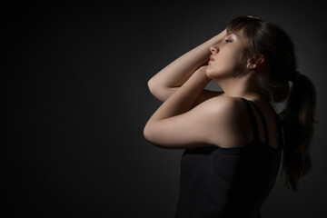 Fototapeta premium Portrait of a beautiful teenage girl posing in beauty style against a dark background