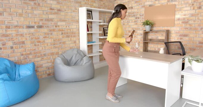 Lifestyle videos indoor of people doing activities at office, businesswoman in office holding wine g