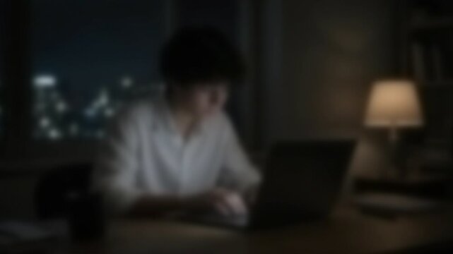 夜にノートパソコンでエントリーシートを入力する就活生、ぼかし処理した4K映像