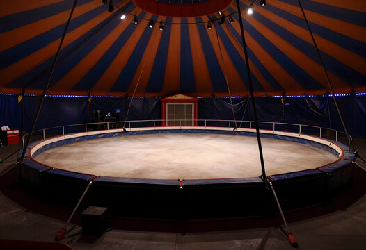 Entertainment and performance industry, empty circus ring inside a large striped tent with stage lighting for theatrical events and live show production