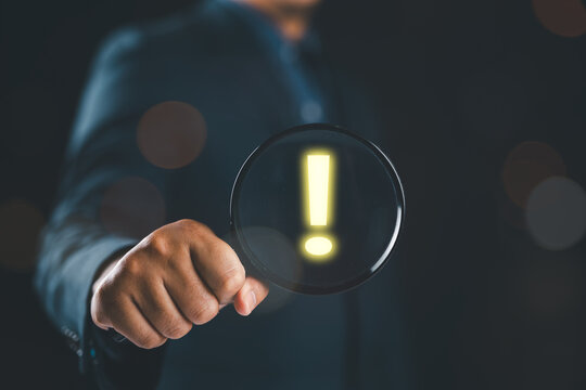 Cybersecurity analyst investigates digital risk alerts using magnifying glass inspection, threat detection system, data breach warning signal, online security monitoring, fraud prevention analysis