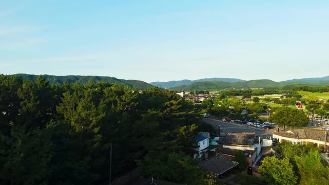 Rising pan drone shot of ancient Silla burial mounds and Gyeongju city skyline
