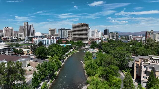 Aerial drone flight over Truckee river approaching Reno skyline in Nevada, USA
