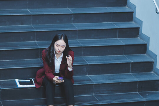 desperate Asian Korean business woman crying alone sitting on street staircase suffering stress and depression crisis being victim of mobbing or fired losing her job
