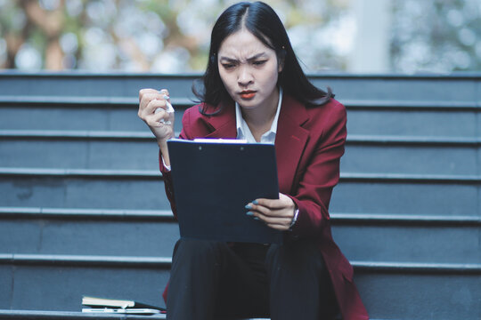 desperate Asian Korean business woman crying alone sitting on street staircase suffering stress and depression crisis being victim of mobbing or fired losing her job