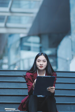 desperate Asian Korean business woman crying alone sitting on street staircase suffering stress and depression crisis being victim of mobbing or fired losing her job