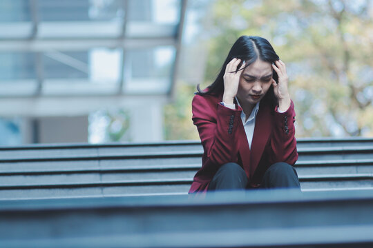desperate Asian Korean business woman crying alone sitting on street staircase suffering stress and depression crisis being victim of mobbing or fired losing her job