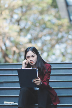 desperate Asian Korean business woman crying alone sitting on street staircase suffering stress and depression crisis being victim of mobbing or fired losing her job