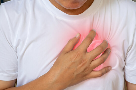 Chest pain shown with a hand pressing the chest and a medical heart overlay. The image illustrates cardiac symptoms, discomfort and cardiovascular health concerns.