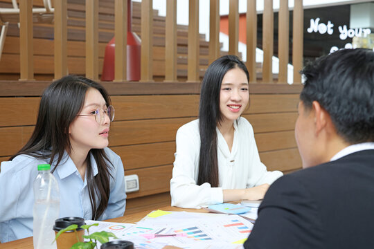 Young Asian Professionals Discussing Business Strategy in Modern Office
